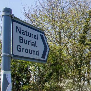 A road sign reading "Natural Burial Ground"