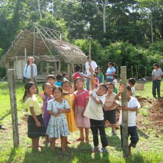 Environmental Law Alliance Worldwide Associate Director Lori Maddox stands behind a group of children in Conejo Village, Belize.
