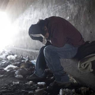 A homeless man tries to rest inside a canal tunnel