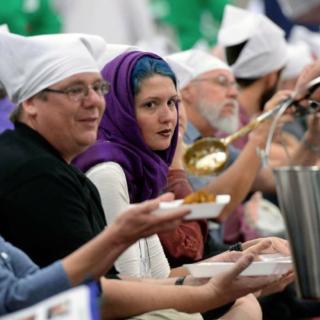 Thousands of participants at the Parliment of the World's Religions wear head covering and sit together as equals on the floor of the Salt Palace Convention Center on Friday while members of the Sikh religious community serve food at a traditional Langar.
