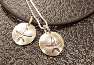 Photo of 2 silver flaming chalice pendants.