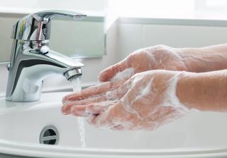 Closeup of a person washing their hands with soap and water