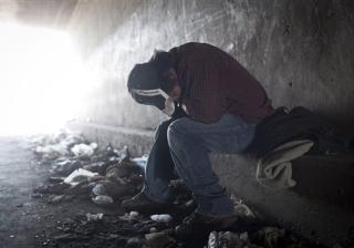 A homeless man tries to rest inside a canal tunnel