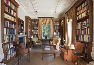personal library with comfortable chairs and floor-to-ceiling bookshelves