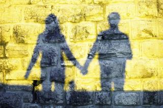 Silhouette of two people holding hands