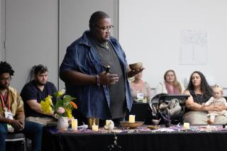 Mathew Taylor strikes a singing bowl during a worship hosted by druumm (Diverse Revolutionary UU Multicultural Ministries) at GA 2019.