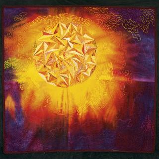 picture of a quilt. stylized sun in top left quadrant consisting of reds, oranges and yellows, rapidly fading to reds, purples and dark blues.
