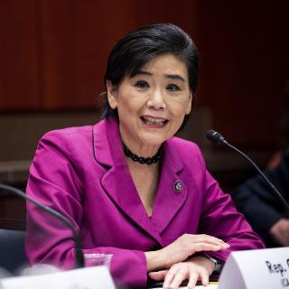 An Asian American woman at a microphone