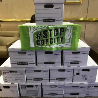 A stack of boxes with petitions against a proposed 'Cop City' sit in an office