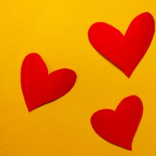 Three red hearts on a yellow background.
