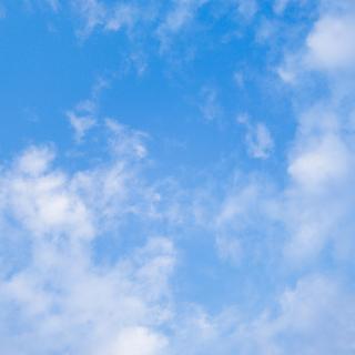 A blue sky with wispy white clouds.