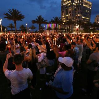 Thousands hold candles in the air after a bell tolled for each of the victims, during a vigil Monday, June 13, 2016, in Orlando, Florida.
