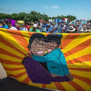 Mother and child banner at the front of a protest march