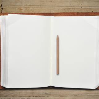  Open leather book with pencil on wooden table 