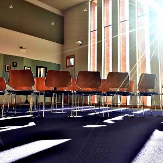 Photograph entitled First UU Congregation of Ann Arbor, Michigan (December 2018). A room with chairs and sunlight streaming in.
