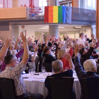 Delegates raise hands at the 2016 Annual Meeting of the Canadian Unitarian Council