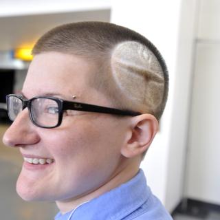 Person with flaming chalice shaved into their hair