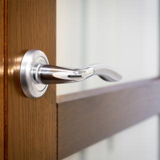 Part of open door with silver door-handle - Stock image