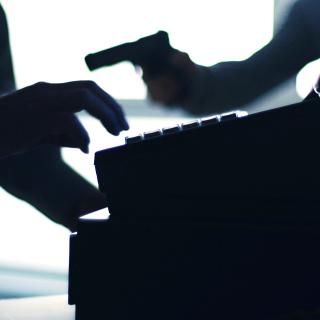 silhouette of cash register and armed robber