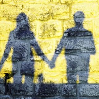Silhouette of two people holding hands