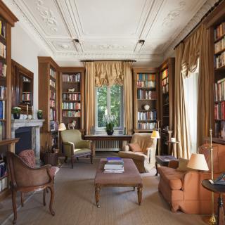 personal library with comfortable chairs and floor-to-ceiling bookshelves