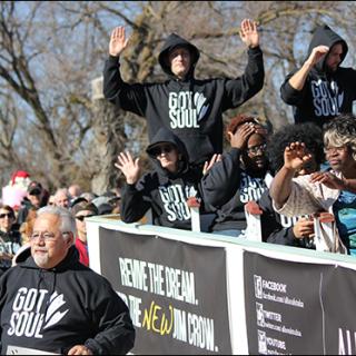 members of All Souls Unitarian Church in Tulsa march in the Martin Luther King, Jr. Day Parade in Tulsa wearing hoodies.