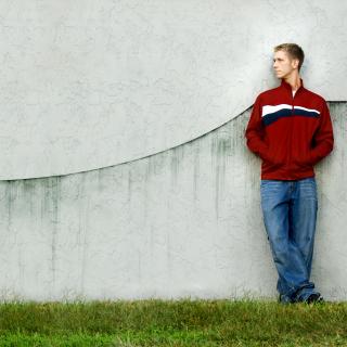 Young Man Leaning on Concrete Wall