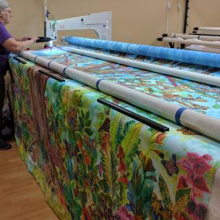 Pat Sturtzel works the long arm quilting machine for a collaborative quilt.