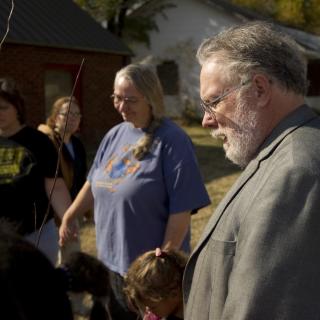 The Rev. Ron Robinson, his wife Dr. Bonnie Ashing, and other A Third Place supporters pray over a tree they just planted outside the church they are buying to house their community ministry in Turley, Oklahoma.