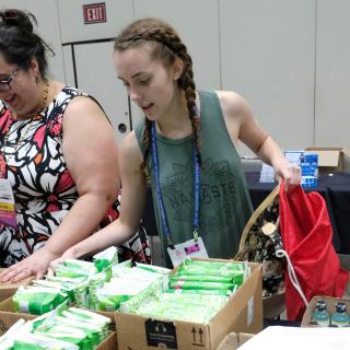 Audra Friend, UUA Communications Coordinator for Multicultural Ministries, and Marie Bennett, a youth from Davies Memorial UU Church in Camp Springs, Maryland, fill purses and bags with self-care items.