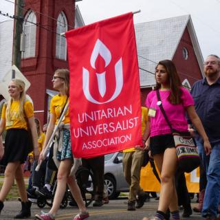 Youth carry a UUA banner 