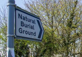 A road sign reading "Natural Burial Ground"