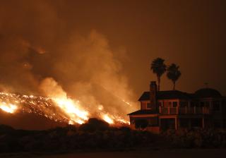 A wildfire threatens homes as it burns along the 101 Freeway Tuesday, Dec. 5, 2017, in Ventura, Calif.
