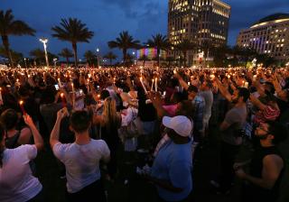 Thousands hold candles in the air after a bell tolled for each of the victims, during a vigil Monday, June 13, 2016, in Orlando, Florida.