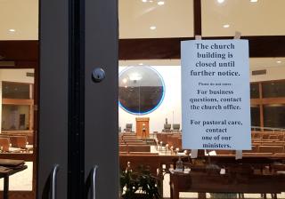 Photo of a sign on the door of the UU Church in Baton Rouge, La., saying "this church building is closed until further notice."