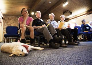 Three visitors, plus a service dog, attend worship one Sunday in June.