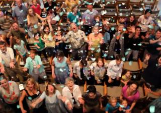 Confetti showers on members of First Unitarian Church of Rochester as they sing about “Coming Home.” (Adam Durand)