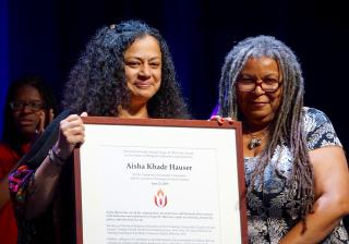 Aisha Hauser receives the Angus H. MacLean Award from Jessica York at the 2018 General Assembly