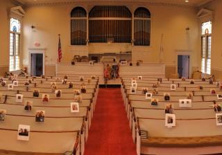 The Rev. Lara Hoke placed photographs of congregants of First Church Unitarian in Littleton, Massachusetts, on the pews where she was accustomed to seeing them after the congregation stopped holding worship services during the covid-19 shutdown.
