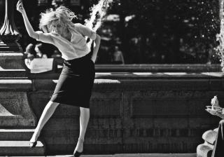 Greta Gerwig dancing in front of fountain.