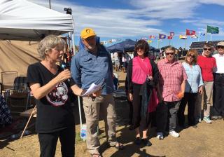 Members of the Quimper, Whidbey Island, and Bismarck Mandan UU congregations stand in front of the people at Oceti Sakowin camp, reading a letter signed by more than 100 UU ministers.