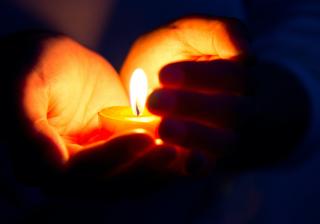 hands holding a lighted candle
