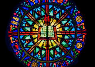 Image of a dramatic stained glass window depicting world religions at the First Unitarian Universalist Society of Syracuse NY.