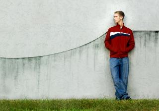 Young Man Leaning on Concrete Wall