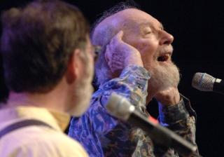 Pete Seeger singing at a microphone.