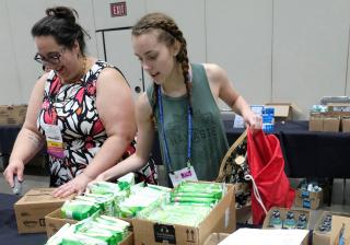 Audra Friend, UUA Communications Coordinator for Multicultural Ministries, and Marie Bennett, a youth from Davies Memorial UU Church in Camp Springs, Maryland, fill purses and bags with self-care items.