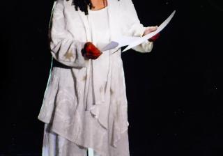 Photo of Poet, playwright, educator, and activist Sonia Sanchez, reading her poetry on stage. 
