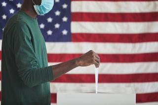 casting a vote with an American flag in the background