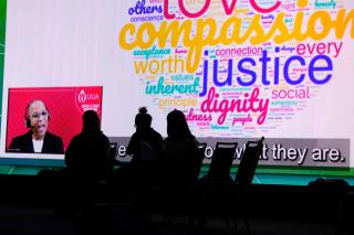 A photo of the Rev. Cheryl M. Walker on screen with a word cloud including the words love, compassion, justice, and dignity