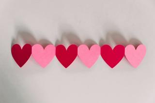 A row of connected pink and red paper hearts.